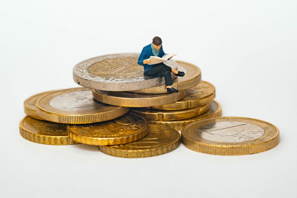 A little man figurine sitting on English money