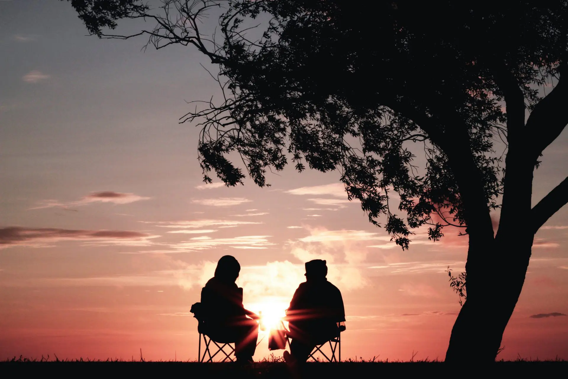 Two people silhouetted against the sunset